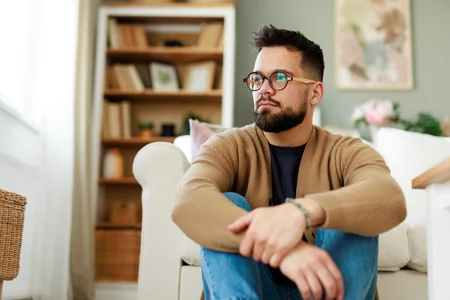 Bearded man sitting on the floor representing trauma and PTSD therapy